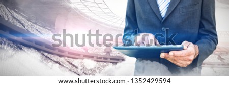 Midsection of businessman using digital tablet  against computer graphic image of stadium