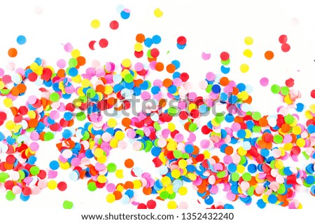 Colorful paper confetti and colored twirled party serpentine on a white background with copyspace in a greeting card and party invitation template design for New Year Christmas, Mardi Gras or birthday