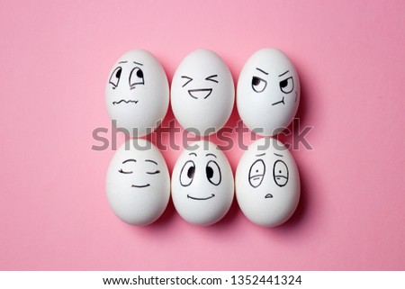Funny Easter eggs with facial expressions. Eggs with different faces on pink background. 