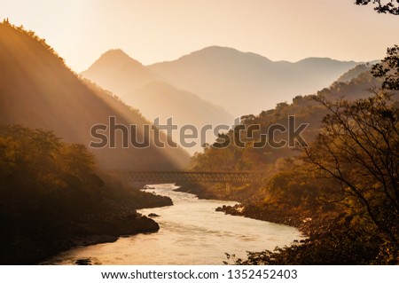Spectacular view of the sacred Ganges river flowing through the green mountains of Rishikesh, Uttarakhand, India. - Image Royalty-Free Stock Photo #1352452403