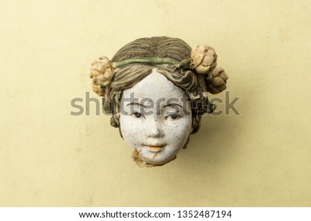 Detail of an old damaged porcelain chinese doll head.