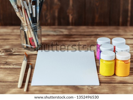  Set of brushes and oil paints. Artist's workshop. Top view of paintbrushes palette and acrylic paints with white canvas. Art picture with copy space and for add text.Items for children's creativity