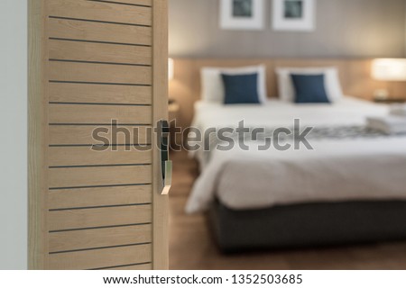 Hotel room with electronics knob door, Condominium or apartment doorway with open door in front of blur bedroom background
