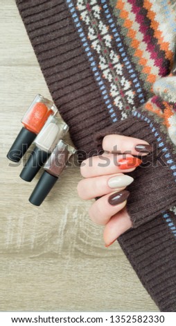 Female hands with long nails with golden brown nail polish