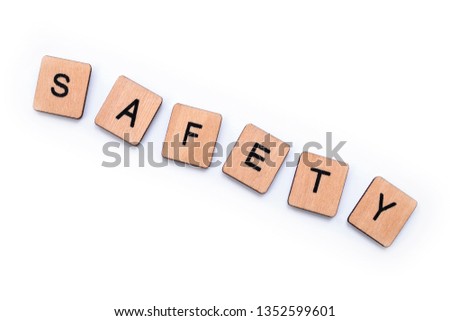 The word SAFETY, spelt with wooden letter tiles over a white background.