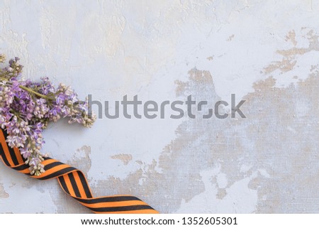 St. George ribbon and lilac, may 9 Victory Day concept, symbol of the Second World war, dark wooden background, copy space