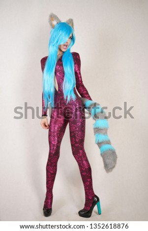 teen girl in an unusual jumpsuit with fur ears and a long fluffy tail loves cosplay and stands on a white Studio background