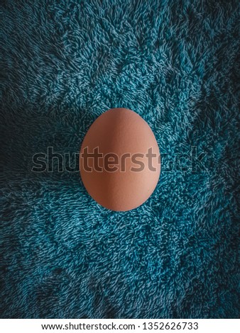 A beautiful picture of an egg with a beautiful towel background. Lying flat, perfetly centred. This picture was shot on a smartphone and colours are tweaked a little bit in post.