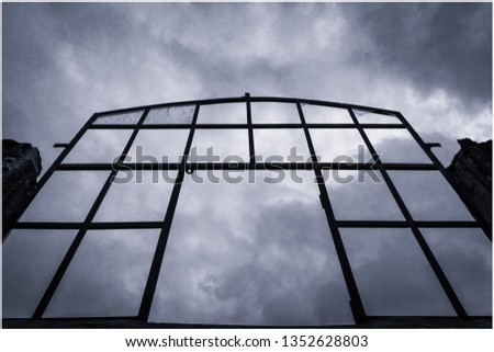 Old abandoned building´s window against a moody sky