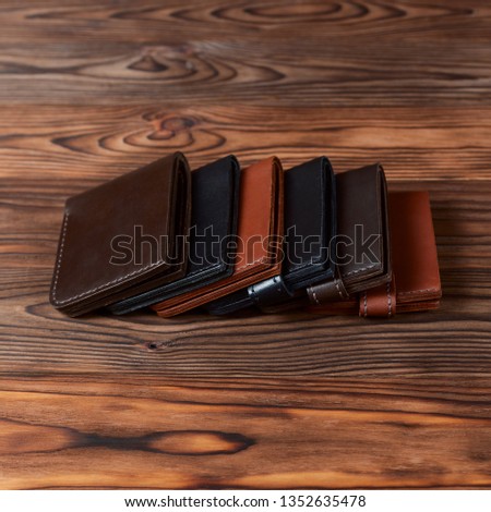 Six handmade leather wallets on wooden textured background. closeup. Wallet stock photo.