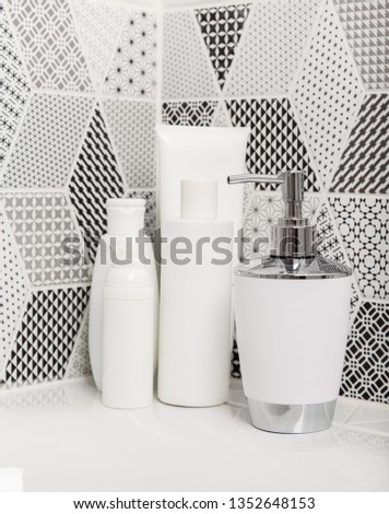 Bathroom, body care products and towel . Bath preparation. White interior of bathroom. Shampoo, shower gel and other bathing accessories. Toothbrush and soap dispenser. details of bathroom 
