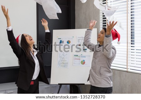 Picture of two asian business are successful in doing business. his hand and another threw the paper. Both of them are very happy and Laughing, Happy time