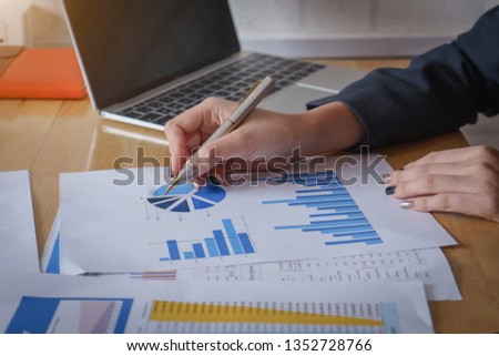 Businesswomen analyzing data financial reports on wooden table. Royalty-Free Stock Photo #1352728766