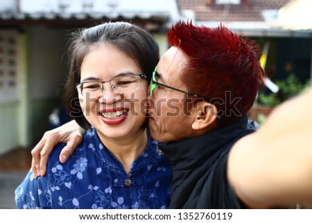 Asian Thai middle-aged couples take a picture to remember in the morning.
