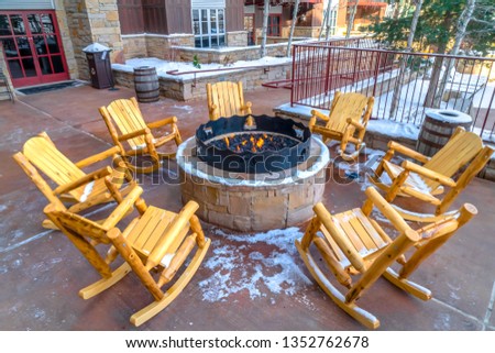 Patio with wooden rocking chairs around a fire pit