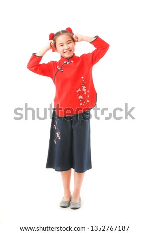 Young little Asian girl with bun chignon hair  in traditional form dress showing how to say hello or greet with Chinese native style on white background.