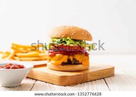 fresh tasty beef burger with cheese and ketchup on wood background