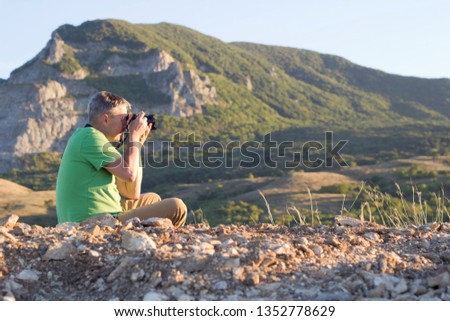 Nature photographer takes pictures in the mountains..
