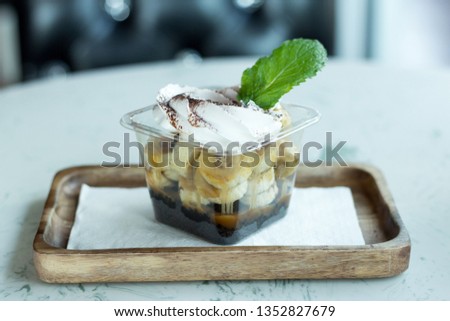 Selective focus picture of Banana panna cotta serving in plastic cup on wood plate