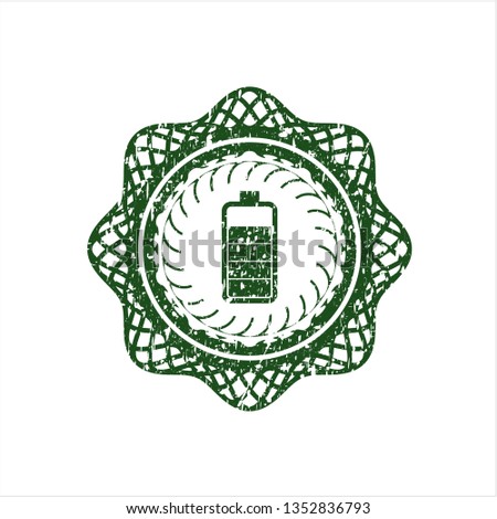 Green battery icon inside distressed rubber grunge texture stamp