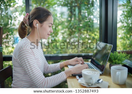 Young woman freelance use laptop and headphone editing video footage in the coffee shop this is lifestyle of content creator 