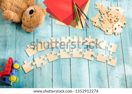 Concept of mock up and pieces of puzzles on the background of wooden table. Education, school, family, baby, pregnancy, maternity, parenting, children concepts