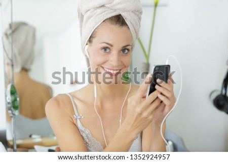 beautiful woman with towel on her head listening a radio