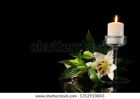 Burning candle and flowers on black background Royalty-Free Stock Photo #1352933843