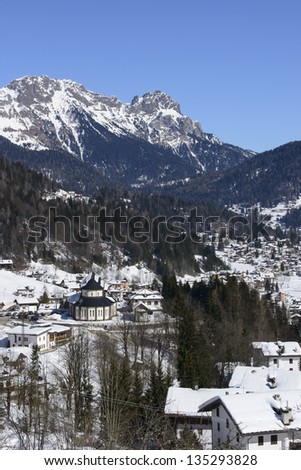 winter landscape, Falcade; winter white view of touristic village in Dolomites, shot under deep blue sky