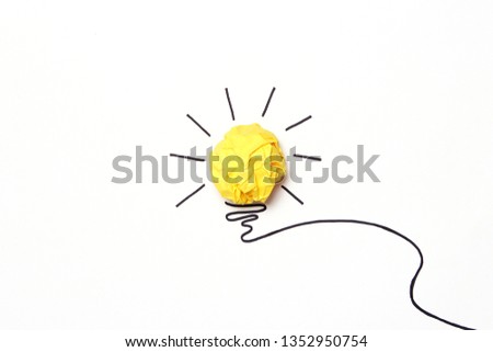 
creative concept "idea", a new idea. Painted light bulb with a crumpled paper yellow ball.