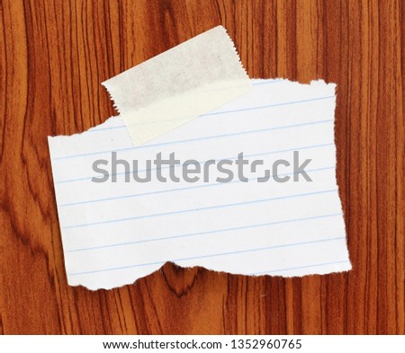 old ripped paper with adhesive tape on wood background