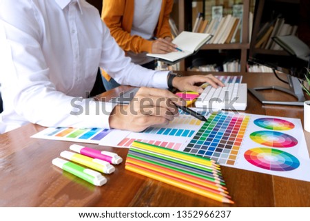 Team work for graphic design working on wood table with computer tablet electronic pen and color chart