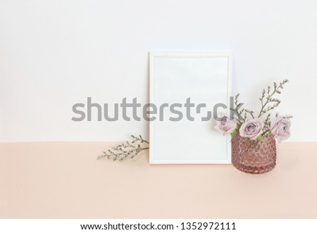 White frame with flowers on the desk
