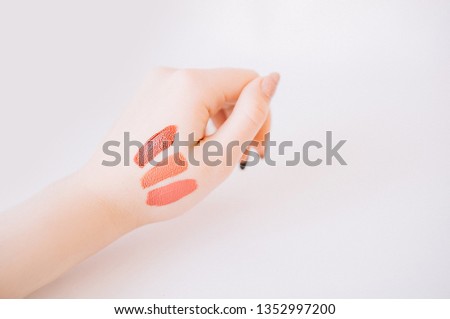 Samples of lipstick on the hand of a woman
