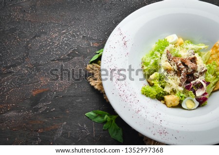 Vegetable Caesar Salad with Veal. In the plate. Top view. Free space for your text. Rustic style.