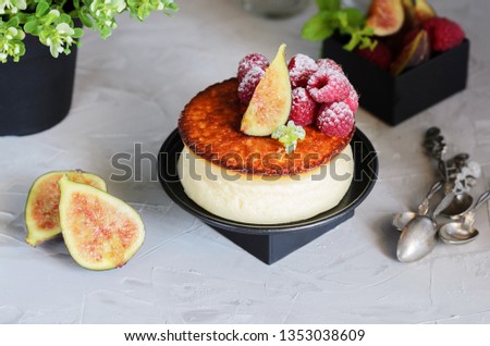 Creamy New York style Cheesecake with berry topping. Example of elegant foodstyling with fruits, fig, raspberry and mint.