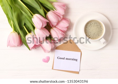 
A cup of coffee, a bouquet of flowers and a card with the words "good morning". flatlay
