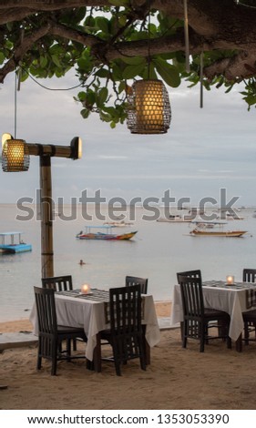 Restaurant tables with a view on the bay . With boats in background, nice artistic light. Perfect place for romantic  dinner. 