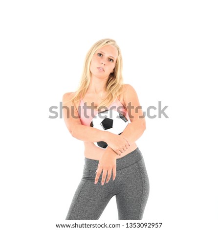 Upset young blonde fitness woman holding a football against a white background
