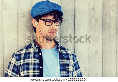 people, music, leisure and lifestyle - man with earphones listening to music on street