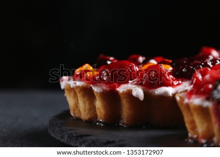 tart with berries on dark background. pie with raspberries and many berries.