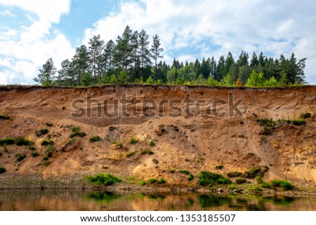 Landscape with cliff near the river Gauja, blue sky and trees. Gauja is the longest river in Latvia, which is located only in the territory of Latvia. 