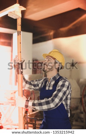 Male worker starting to work with angle grinder at workshop