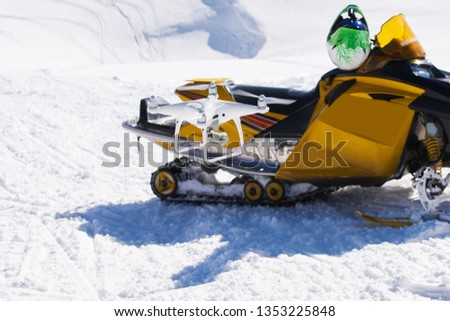 man with drone recording snowmobile
