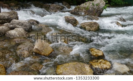 The river runs over large rocks