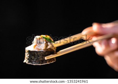 traditional fresh japanese sushi rolls on a black background.