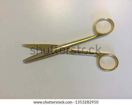 Gold scissors on white table