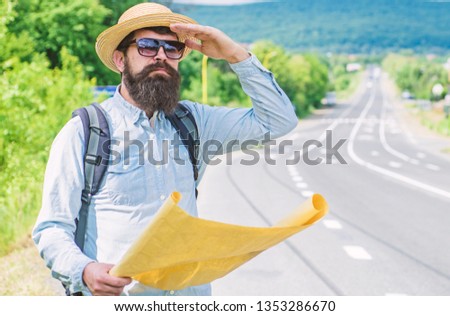 Any transport. Traveler with map looking for hitchhiking transportation alone at edge of road. Tips to get on road. Must know tricks hitchhiking across country. Hitchhiking great way to travel cheap.