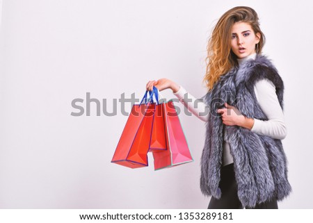 Sales and discount on black friday. Girl makeup face wear fur vest white background. Woman shopping luxury boutique. Lady hold shopping bags. Shopping concept. Fashionista buy clothes in shop.