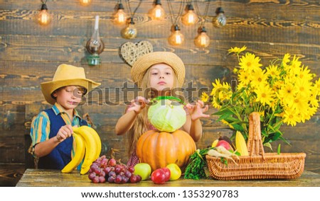 Elementary school fall festival idea. Autumn harvest festival. Celebrate harvest holiday. Children play vegetables wooden background. Kids girl boy wear hat celebrate harvest festival rustic style.